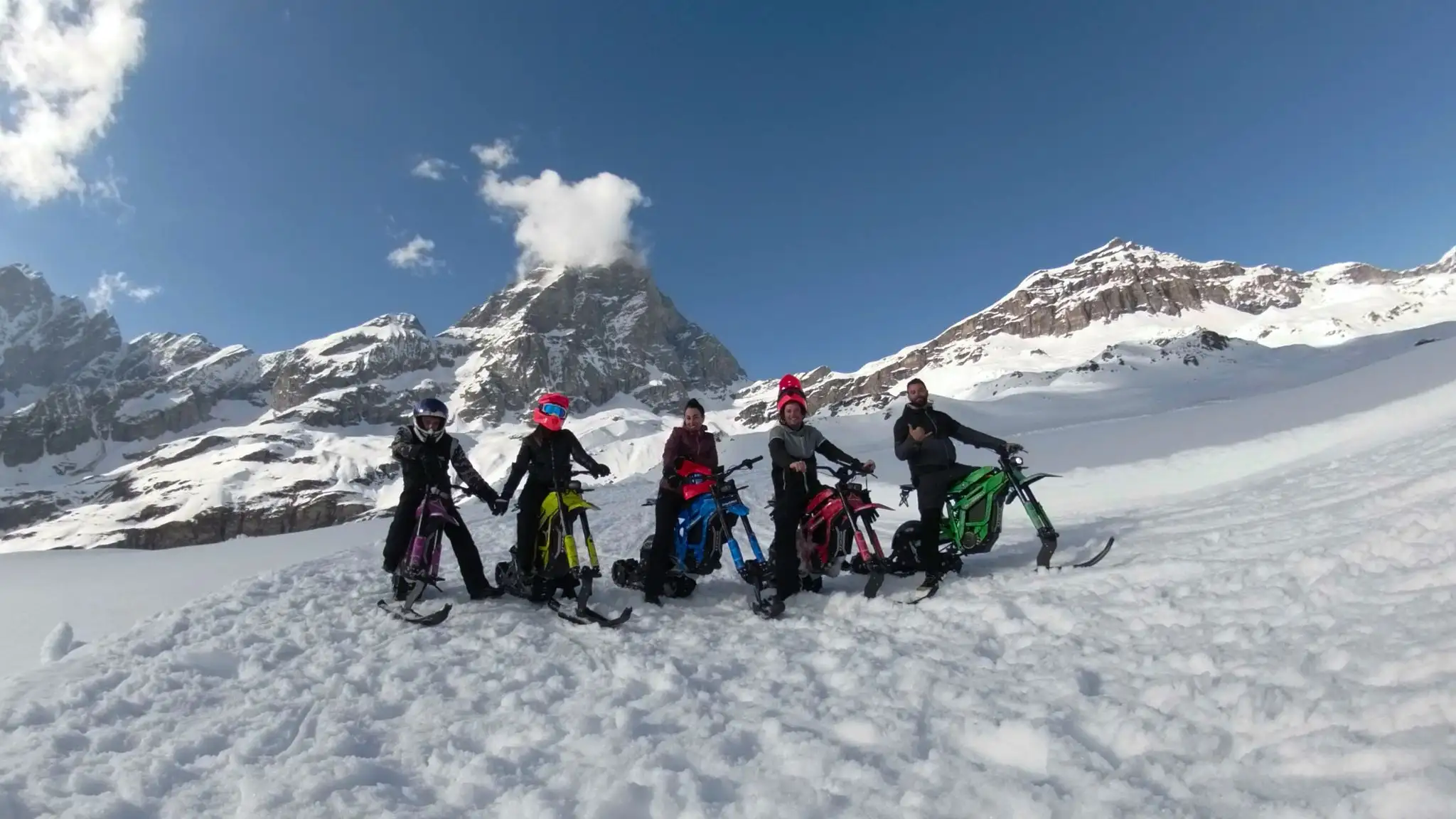 Ritratto di gruppo con snowbike e Cervino sullo sfondo